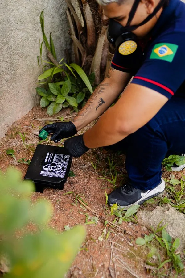 Técnico da Imunizadora Ribeiro instalando porta-isca