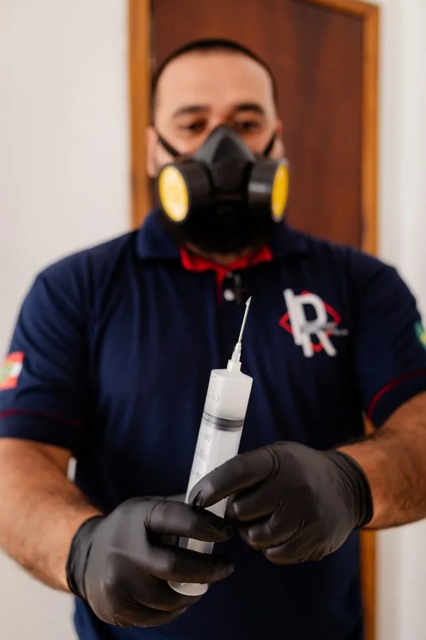 Técnico com seringa para descupinização injetável